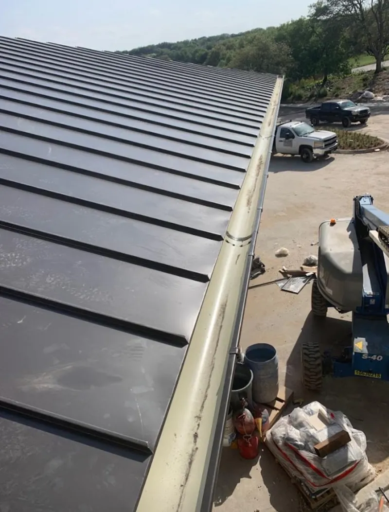 Standing seam panel and gutter detail on a metal roofing jobsite in Lehman